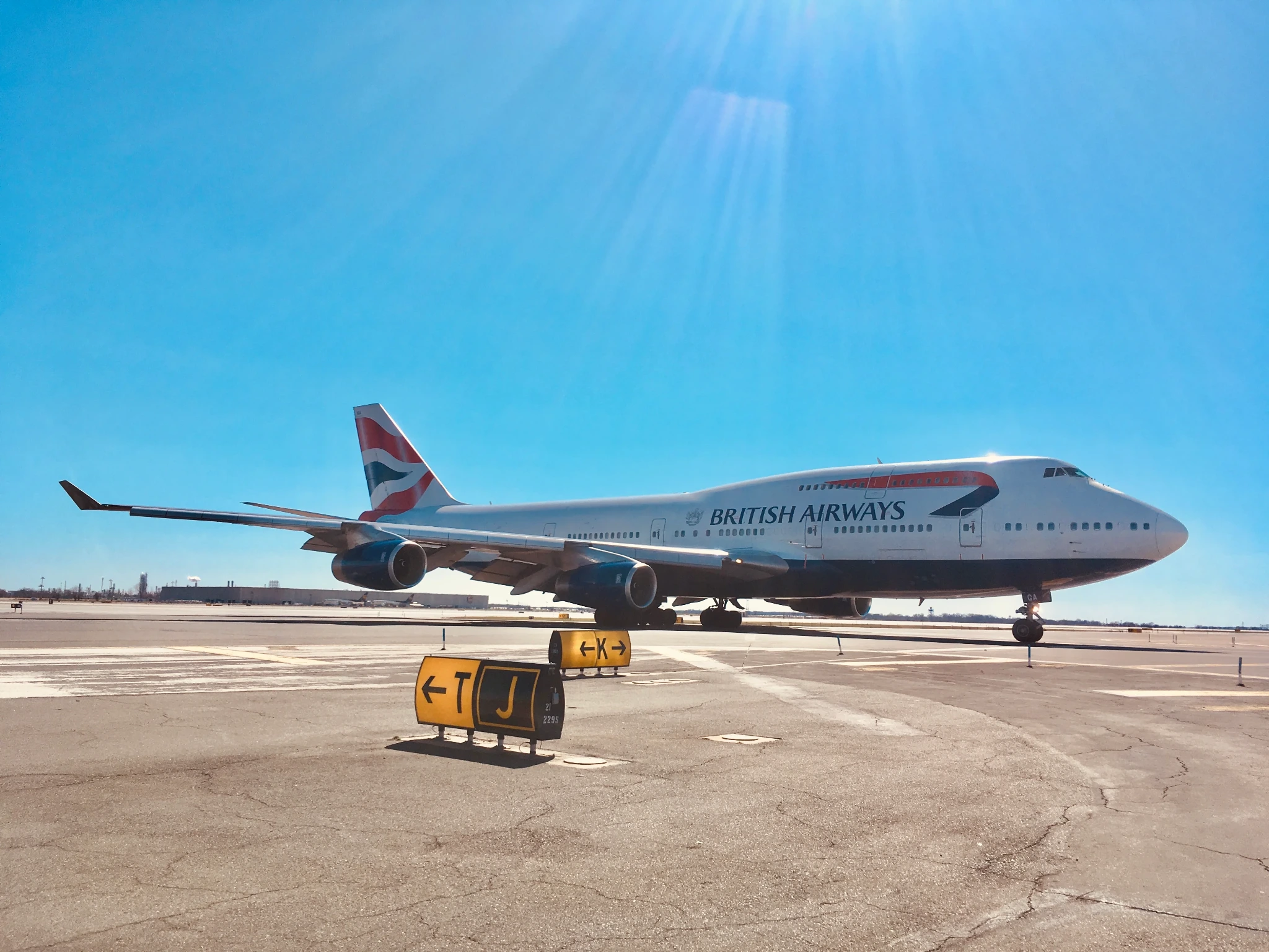 A British Airways Boeing 747 on an airport taxiway beneath a clear blue sky