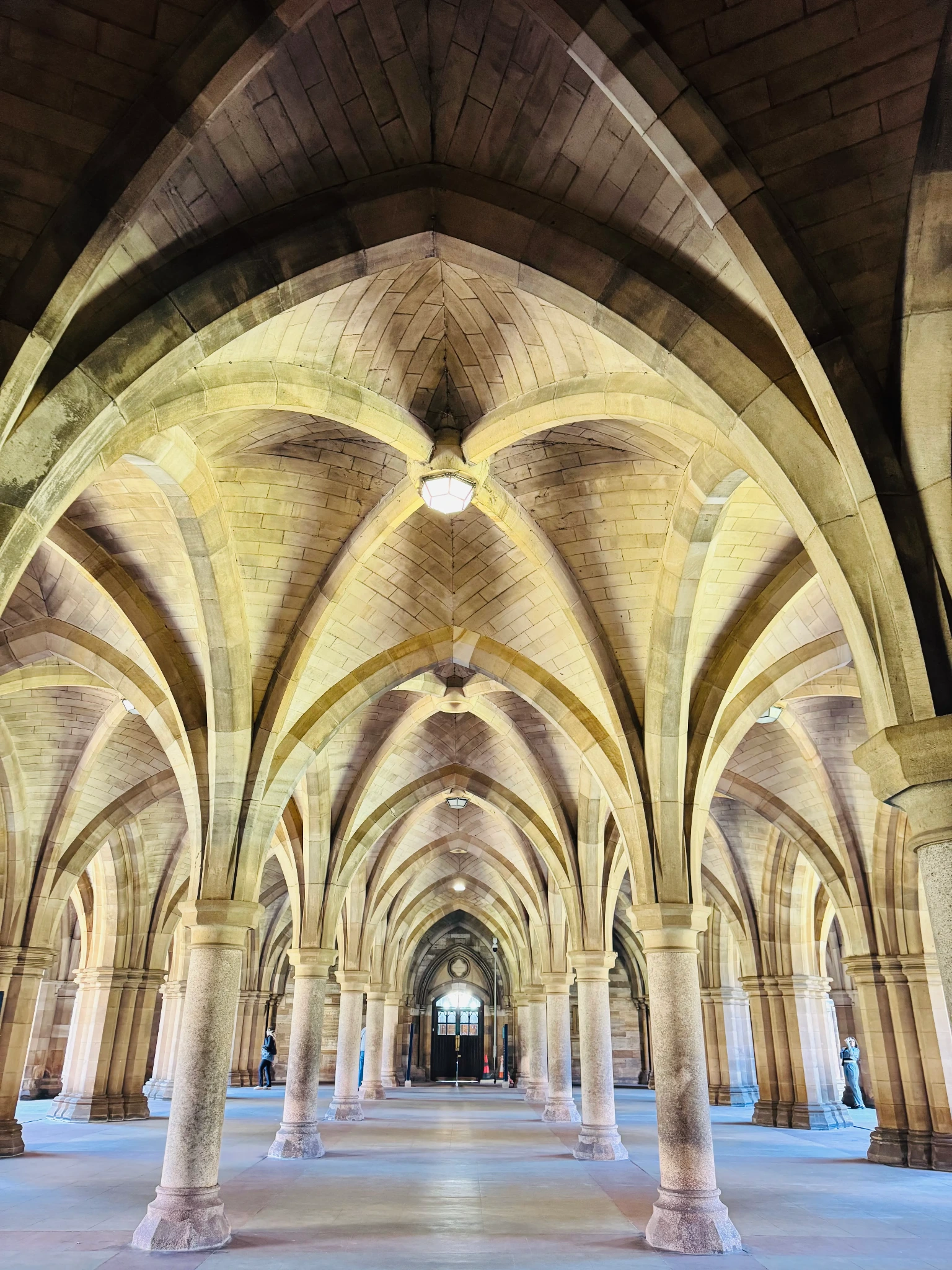 A vaulted stone university corridor with repeating arches