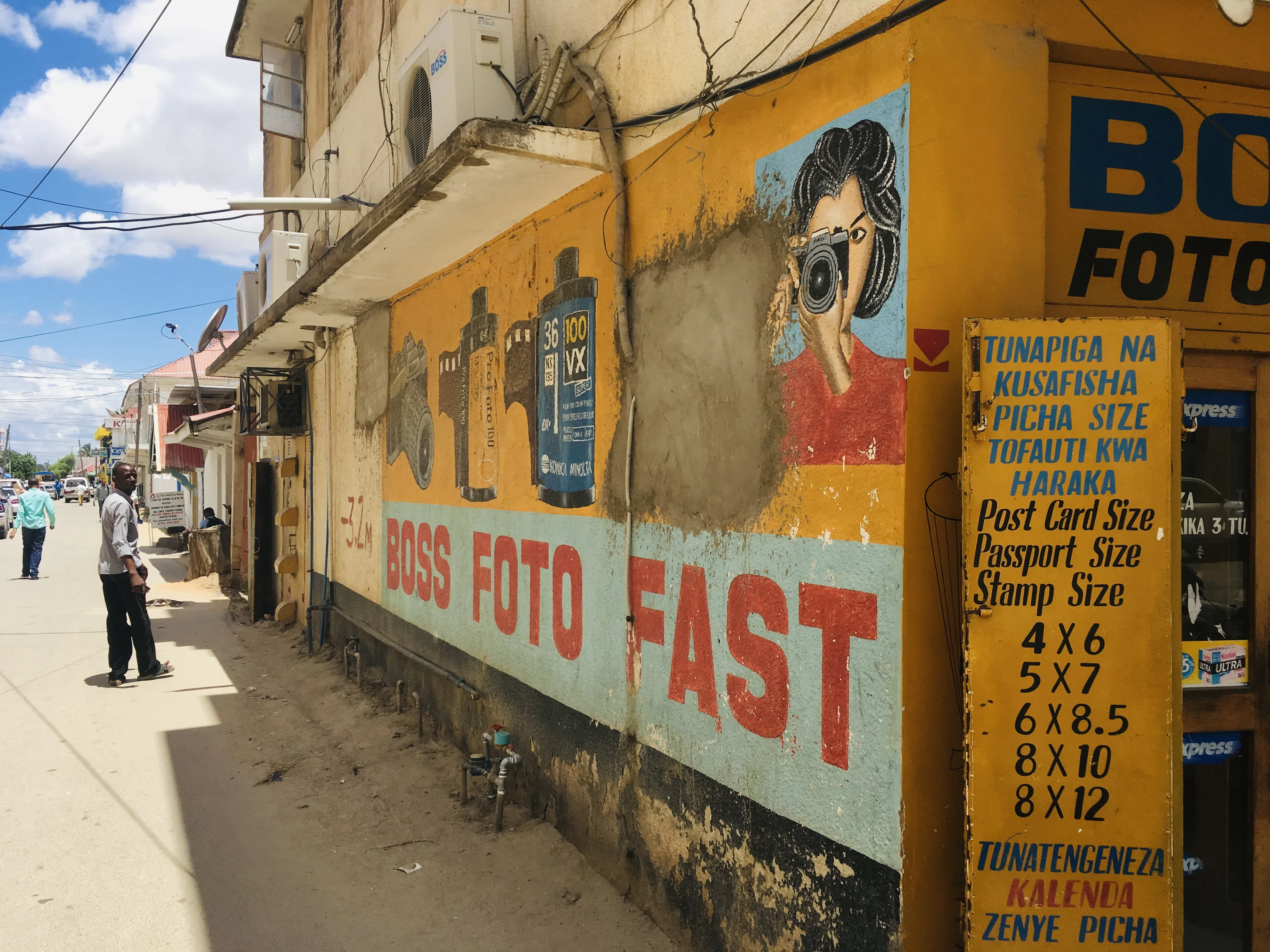 A colorful neighborhood photography shop and street scene