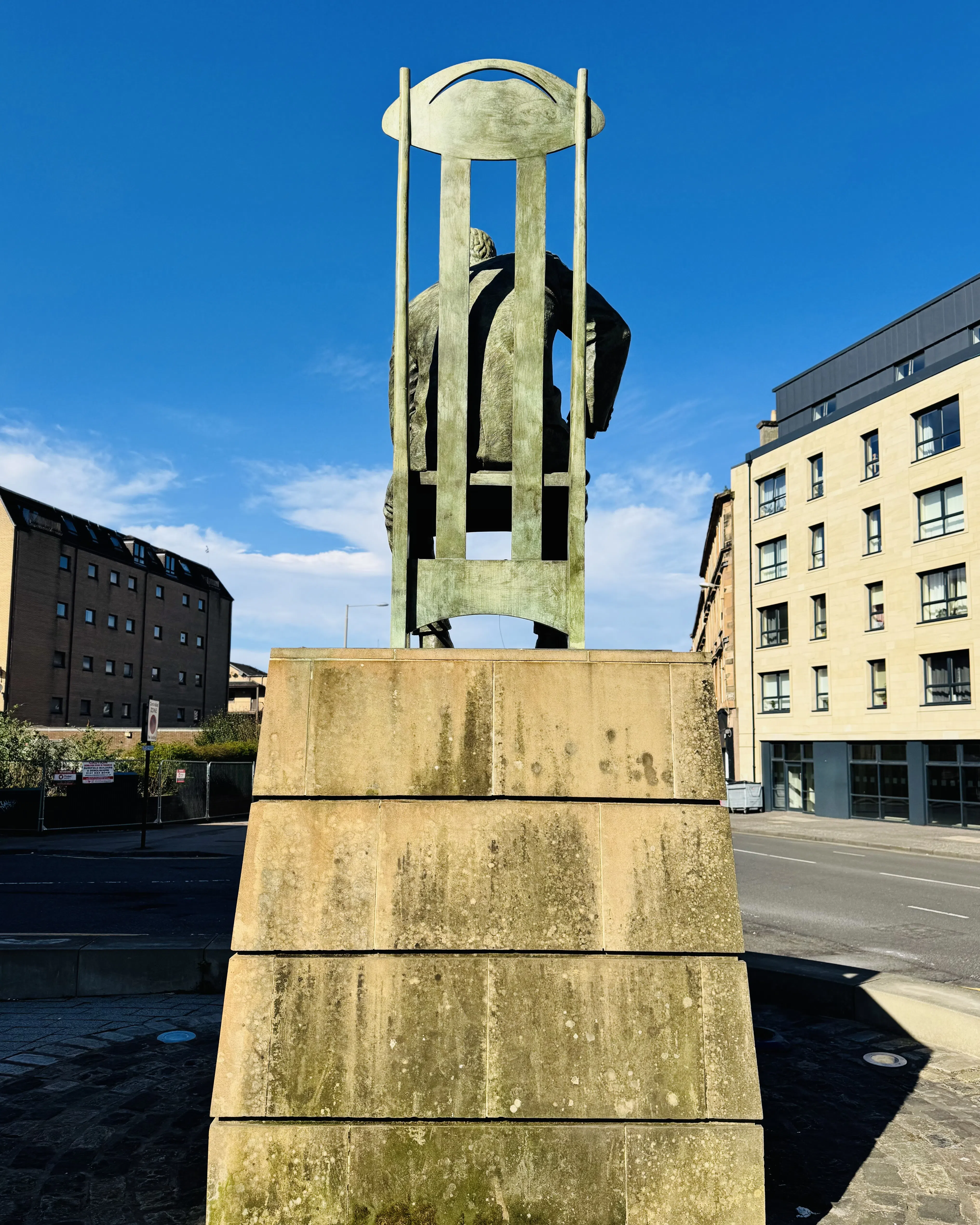A sculptural monument standing in an urban plaza beneath blue sky