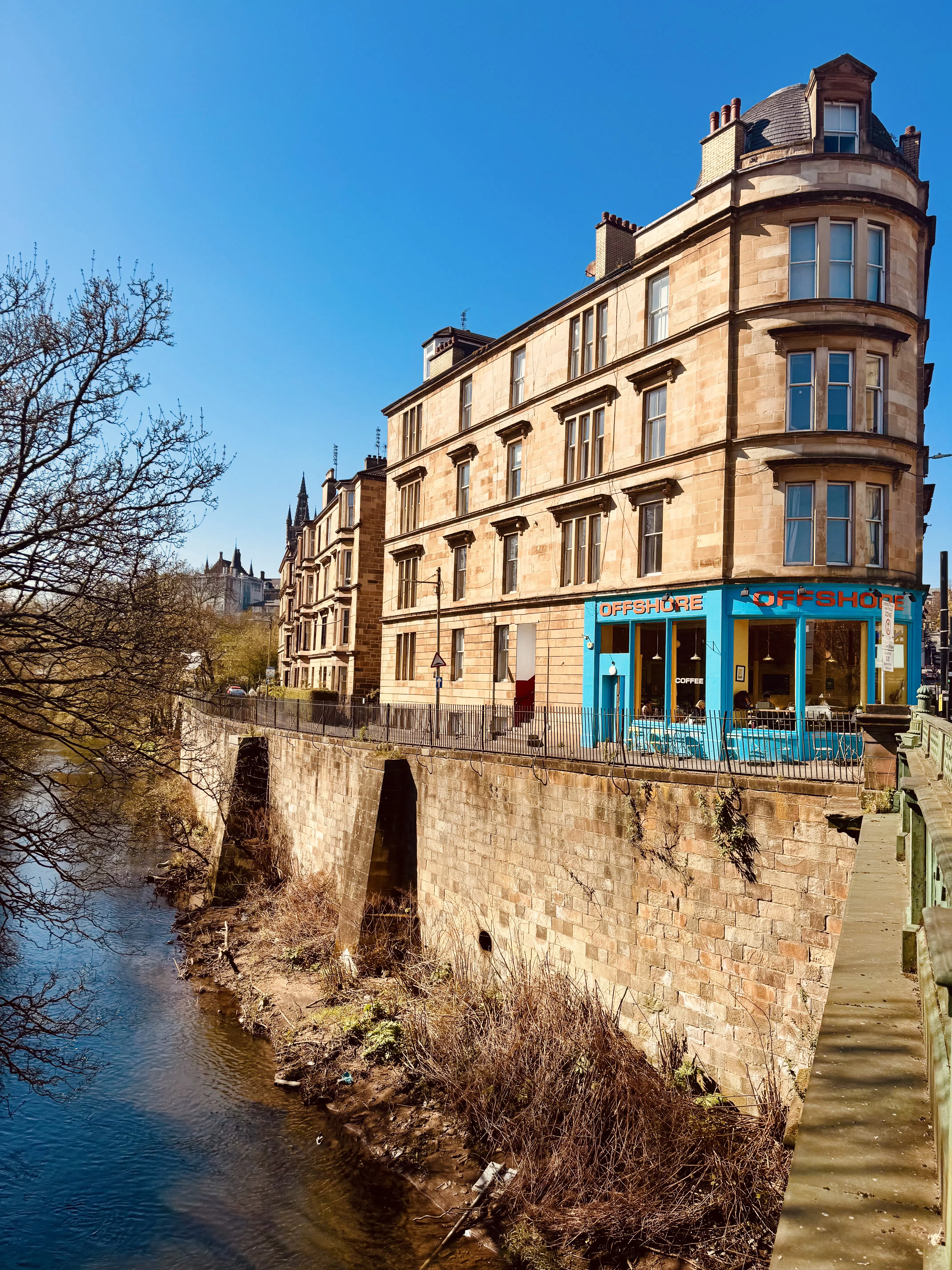 A historic waterside building beneath a vivid blue sky