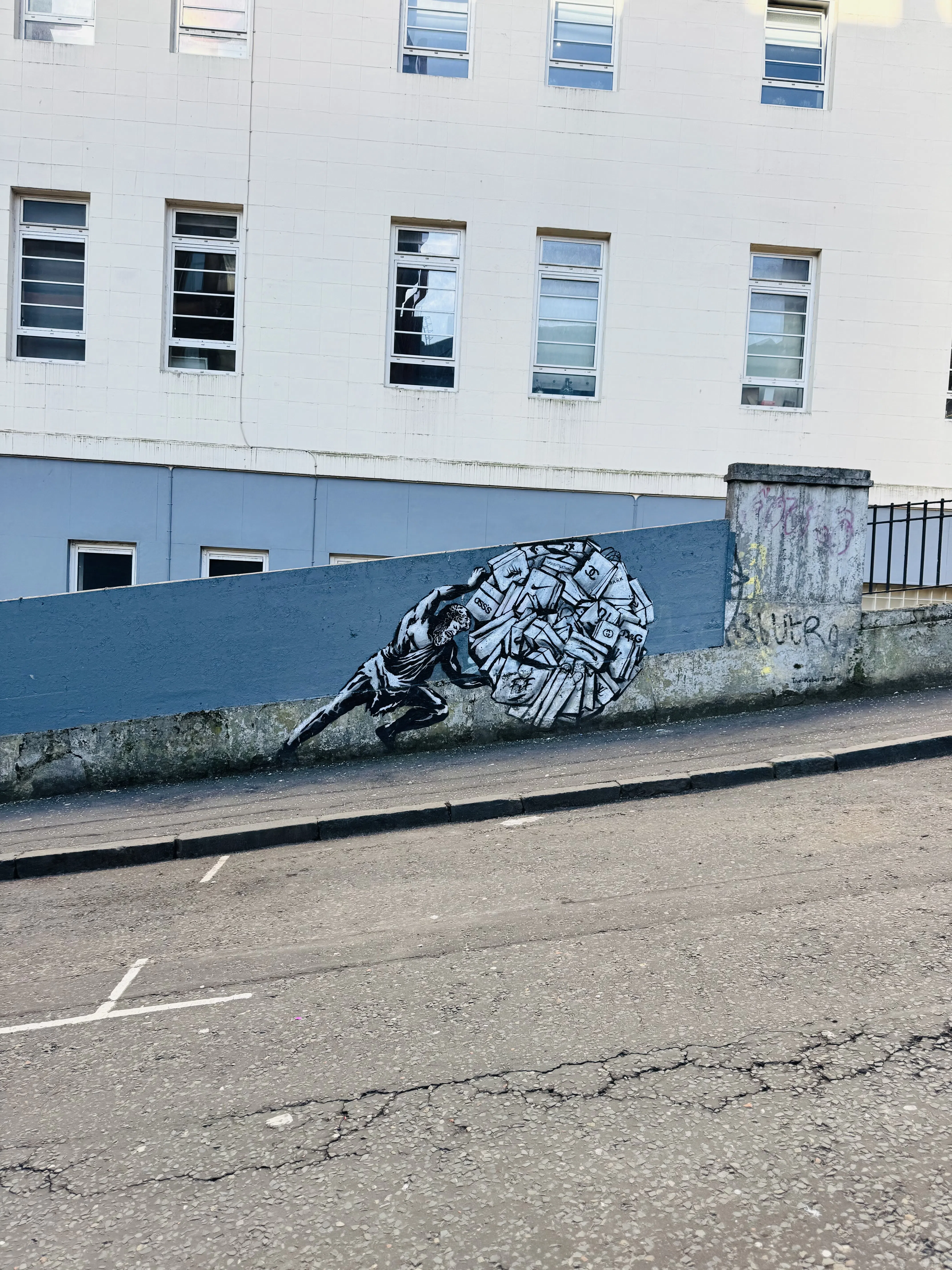 A painted animal mural along a pale urban wall